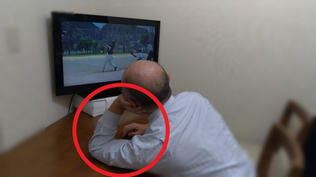 片肘をついてテレビを見ている画像