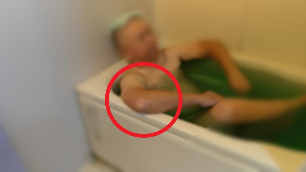 入浴中に両腕を浴槽のフチ横にのせている画像