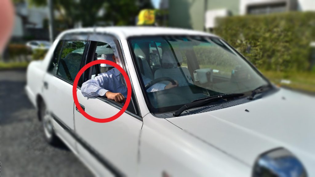 車の運転中に腕を窓枠に乗せている画像